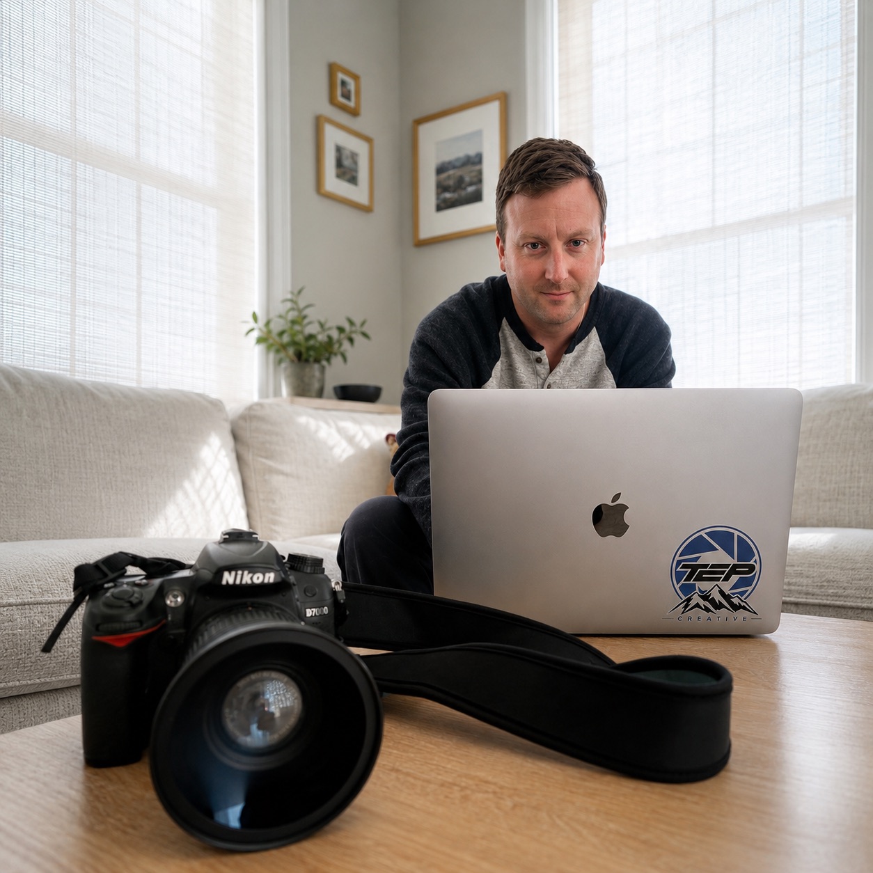 Matthew Teperow working at a laptop with a Nikon camera nearby